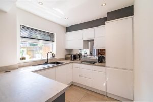 A white gloss kitchen with mirrored splashback